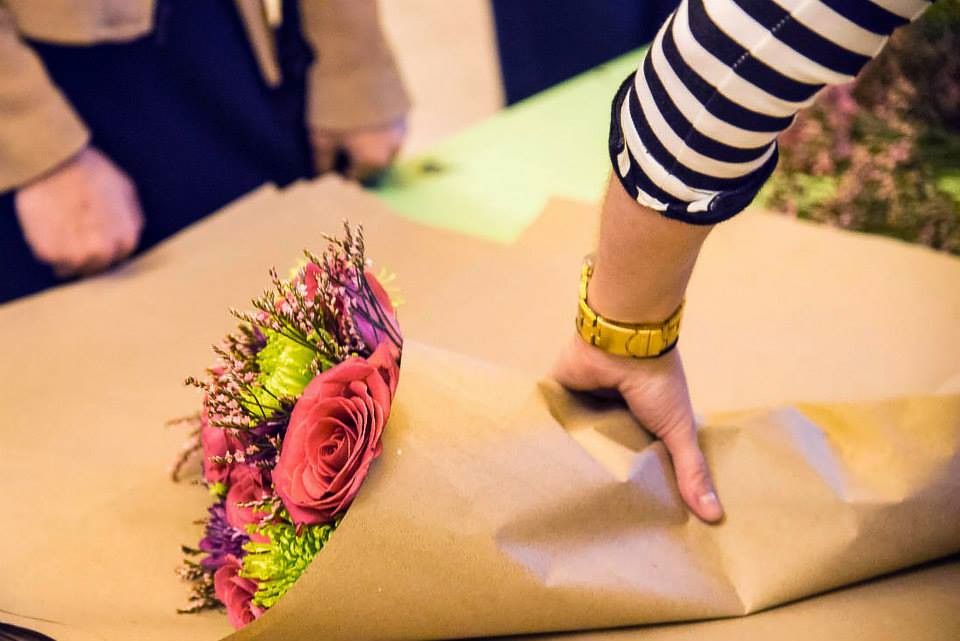 Florist sedang membungkus buket dengan kertas kraft